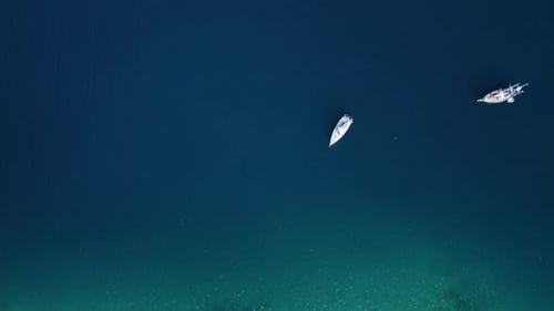 Luftaufnahme von Wasser, Meeresoberfläche und Seeschiffen mit Piers neben der Küstenstadt