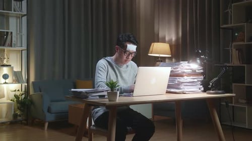 Young Adult Works at Laptop Late at Night