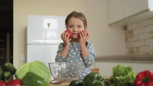 Little Girl Poses with Tomatoes in Bright Kitchen