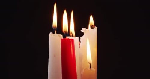 Burning White and Red Candles on a Black Background