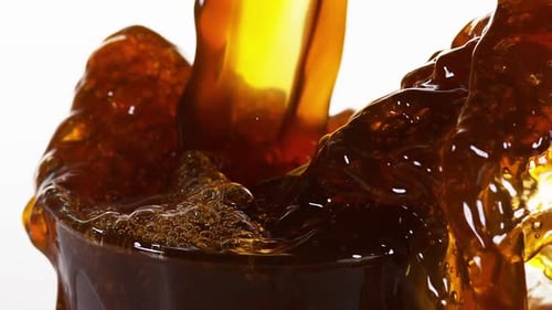 Close Up of Brown Liquid Pouring into Glass