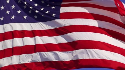 American Flag Waving Proudly Against Blue Sky