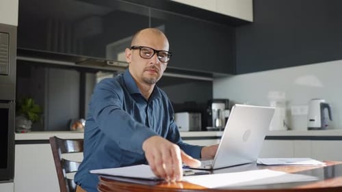 Man Working at Laptop at Kitchen Table
