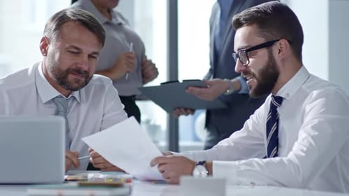 Men Discussing Business Plan in Office