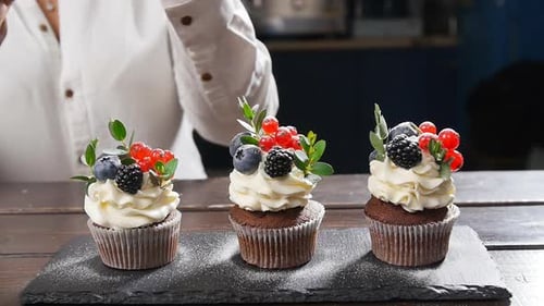 Decorated Chocolate Cupcakes With Berries and White Frosting