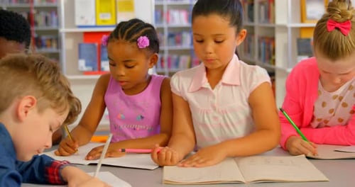 Schoolkids studying together at table in school library 4k