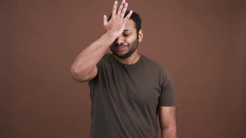 Eastern Man Making Face Palm Gesture Rolling Up His Eyes in Boredom and Shaking Head in Rejection