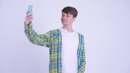 Young Man Takes Selfie with Smartphone Indoors