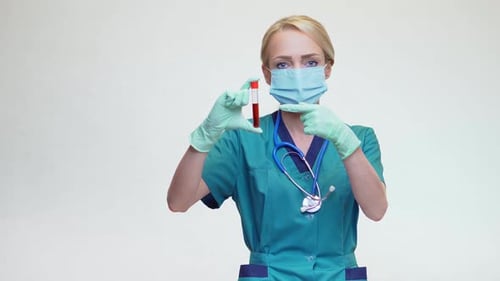 Médico, enfermera, mujer con máscara protectora y guantes de látex, que sostiene un tubo de análisis de sangre