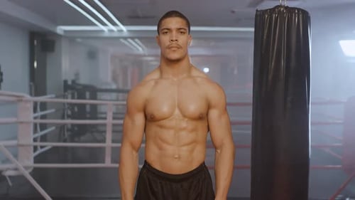 Athletic Man Fighter Trains in Boxing Gym a Muscular Male Takes a Fighting Stance Kickboxing