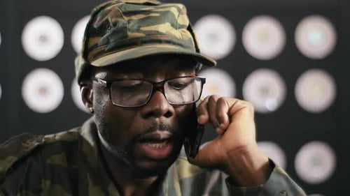 Man in Camo Cap Talking on Phone Indoors