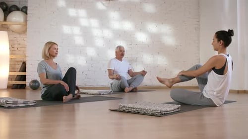 Mari et femme caucasiens ayant un cours de yoga privé en studio