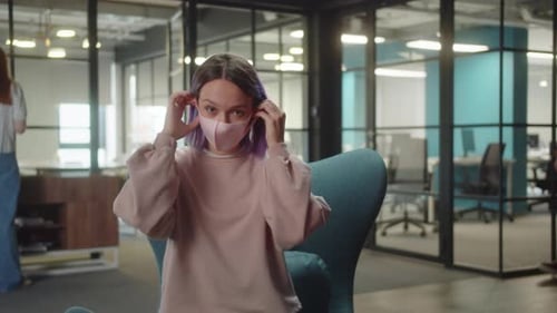 Woman Puts on Mask in Modern Office