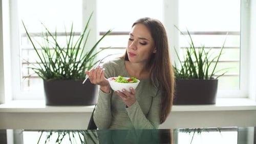 Young Woman Eats Healthy Salad Indoors