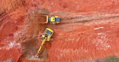 Aerial view of Excavator loading Dirt in Dump Truck