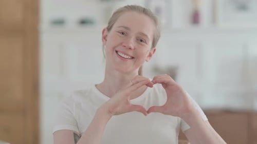 Blonde Woman Making Heart Shape with Hands