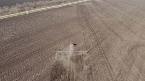 Aerial Footage Modern Red Tractor on the Agricultural Field on Sunny Day. Tractor Plowing Land