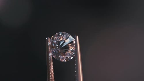 Glistening Diamond Held by Tweezers in Close Up