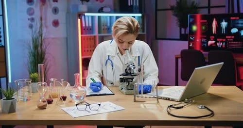 Woman Scientist Using Microscope in Brightly Lit Lab