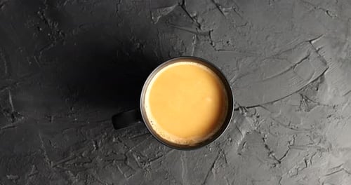 Overhead View of Coffee with Cream on Dark Surface