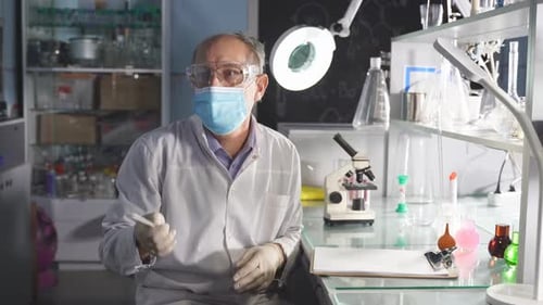 Scientist Working In Lab With Microscope And Glassware