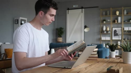 Young Adult Reading Book and Typing on Laptop
