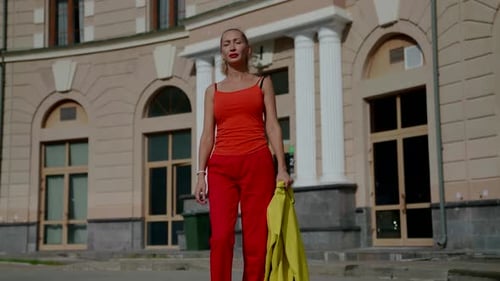 Woman in Red Outfit Walking near Vintage Building