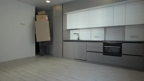 Man Drops Boxes in Modern Kitchen