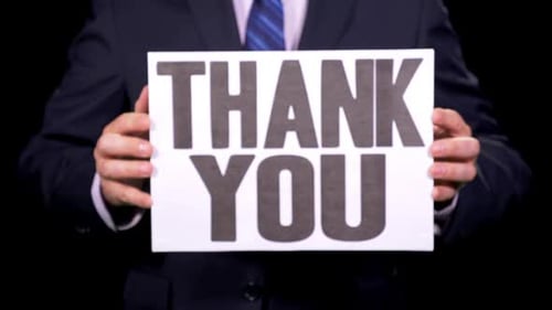 Thank You Sign Held by Person in Suit