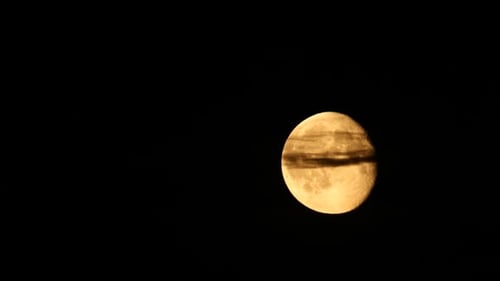Full Moon Rising Through Night Sky in Close-Up