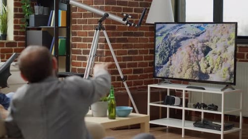 Friends Watching Television at Home with Telescope