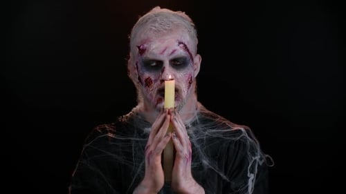 Man with Spooky Makeup Holds Burning Candle