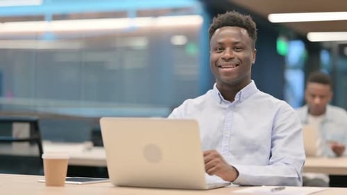Young Man Working with Laptop in Modern Office