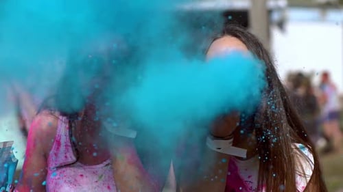 Young Women Celebrate Holi by Blowing Powder