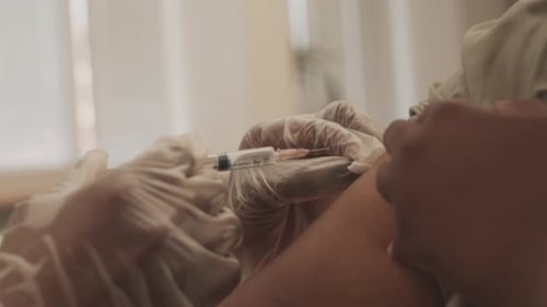 Medical Professional Administers Injection to Adult