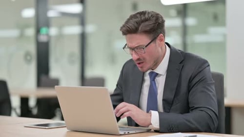 Loss Middle Aged Businessman Reacting to Failure on Laptop in Office