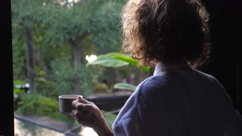 Woman With Coffee Gathers Thoughts in Tropical Setting
