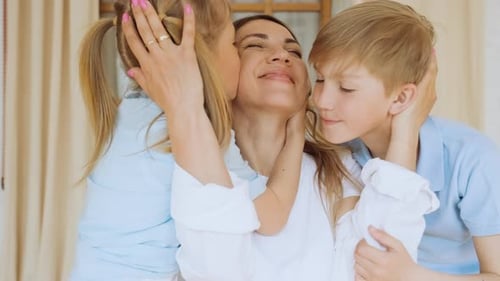Affectionate Mother Embraced and Kissed by Children