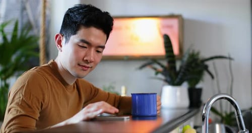 Man Using Smartphone at Kitchen Bar Top