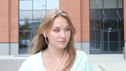 Woman with earphones in urban environment