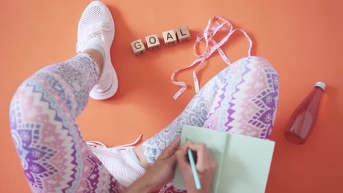 Planning Fitness Goals With Notebook and Measuring Tape