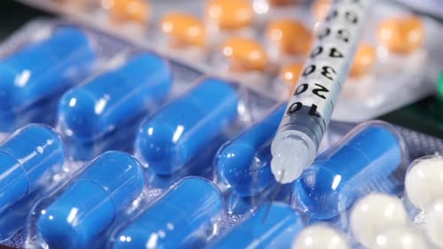 Syringe and Some Different Contraceptive Pills, Close Up, Rotation