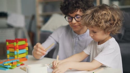 Woman and Child Drawing Together at Home
