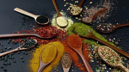 Dry Colorful Spices in Spoons and Bowls with Fresh Seasoning on Dark Background Top View