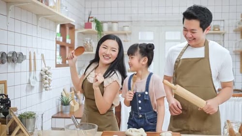 Asian happy family stay at home in kitchen spend time together baking bakery and foods with kid.