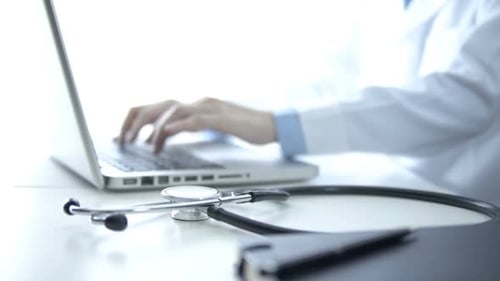 Medical Professional Using Laptop in Bright Clinic