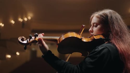 Woman Playing Violin in an Elegant Theater