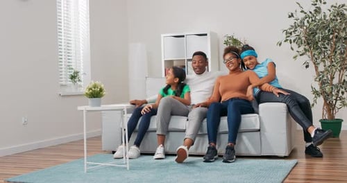 Happy Family Relaxing Together on Couch in Living Room