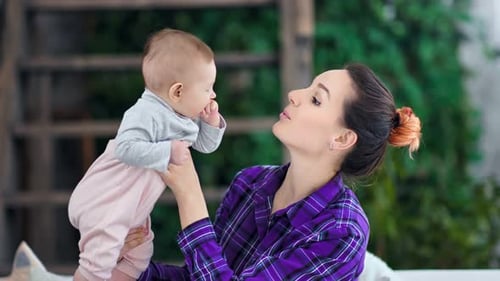 Happy Mother Holding Up Her Infant Child