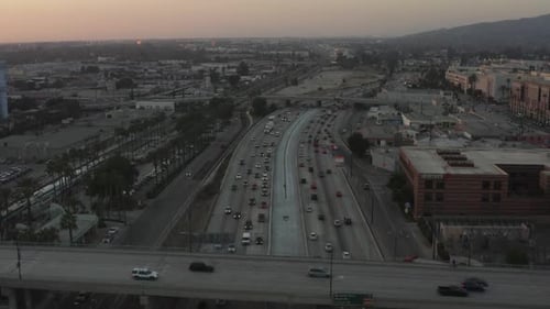 AERIAL: Over Busy Highway at Sunset with Palm Trees in Burbank, Los Angeles, California, Sunset